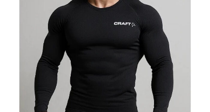 Очень накачанный блондин с короткой стрижкой позирует в чёрном термокостюме Craft, стоя на светлом фоне, с прямым уверенным взглядом и подчёркнутой мускулатурой.